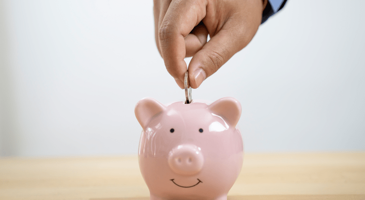 First-time homebuyer putting coin in piggy bank