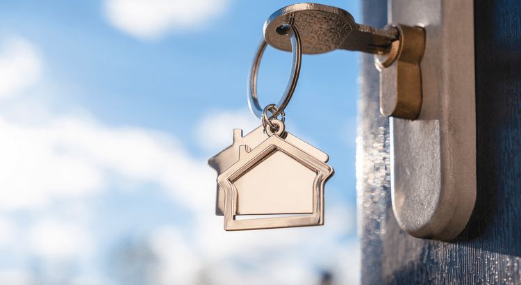 closeup of house keychain and key in door lock