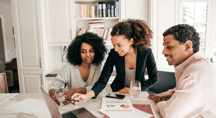 Real estate professional and clients looking at property asking price on laptop