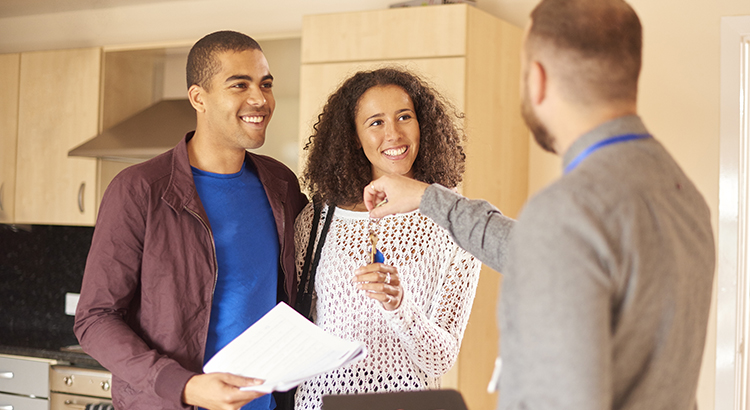 First-time homebuyers getting keys to their new home.