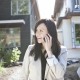 Real estate agent standing near house talking on cell phone