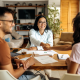 Agent smiling and shaking the hands of new clients after a confident conversation