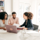 Agent sitting down to educate two clients in a kitchen.